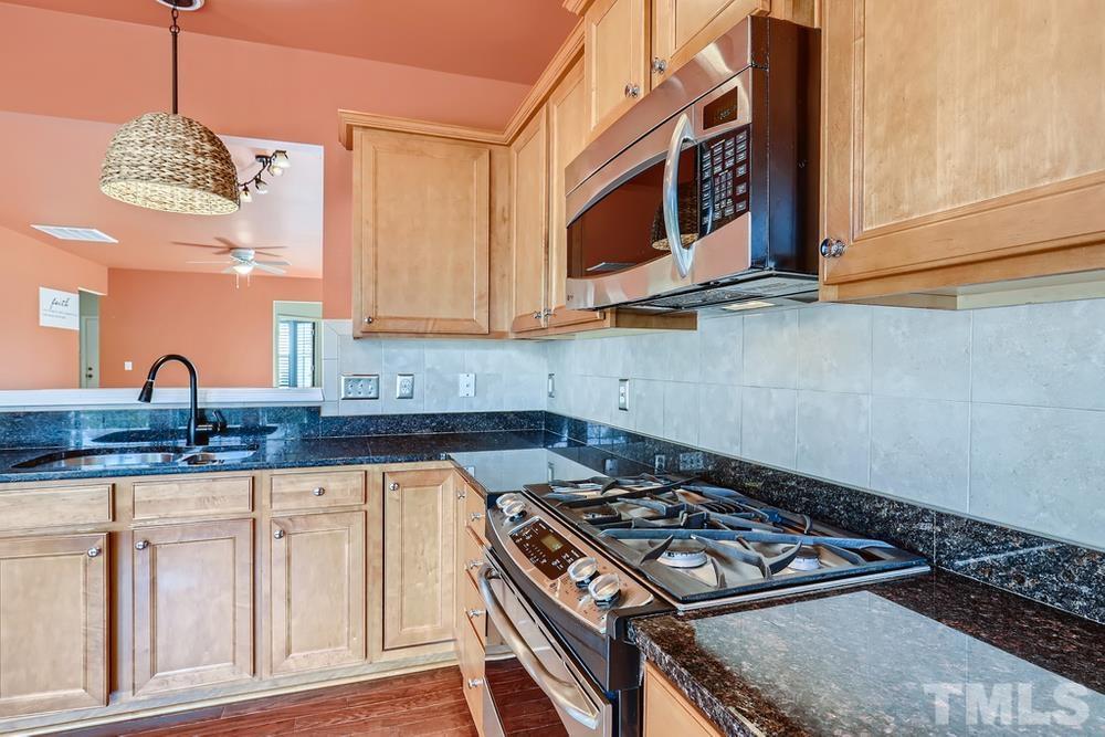 564 Tomkins Loop Cary, NC 27519 - Photo 9 of 28 a kitchen with granite countertop a stove and a sink