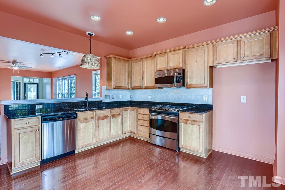 564 Tomkins Loop Cary, NC 27519 - Photo 10 of 28 a kitchen with stainless steel appliances granite countertop a stove a sink and a refrigerator