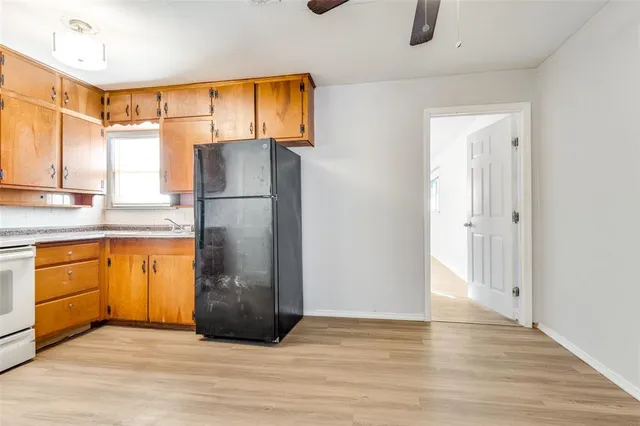 a view of a kitchen with wooden floor and refrigerator