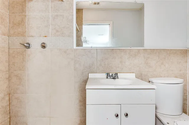 a bathroom with a sink a toilet and a mirror
