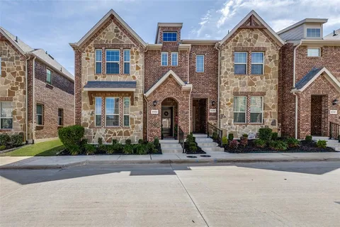 front view of a brick house with a yard