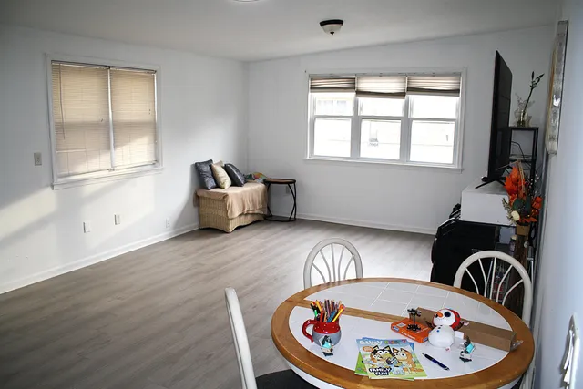 a room with wooden floor and windows