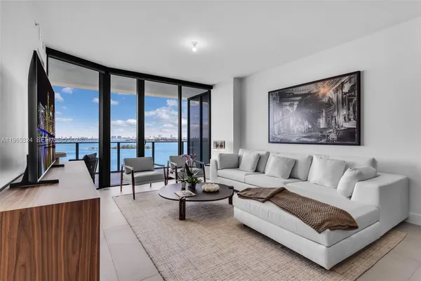 a living room with furniture and a floor to ceiling window