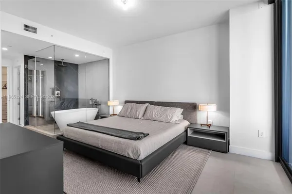 a bathroom with a double vanity sink a mirror and a bathtub