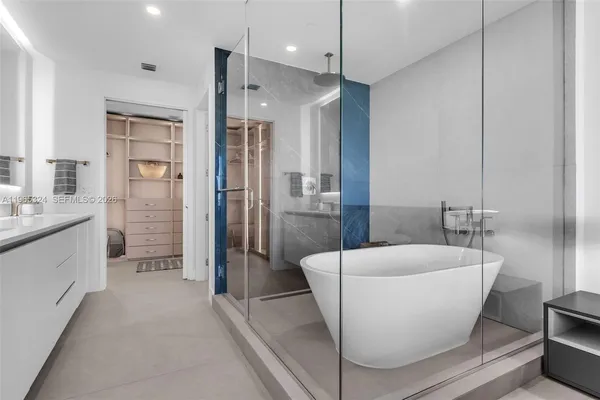 a living room with a couch and a walk in closet with wooden floor