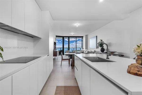 a kitchen with stainless steel appliances white cabinets and wooden floor