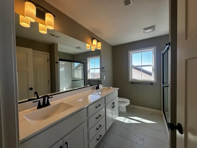 a bathroom with a double vanity sink and a mirror