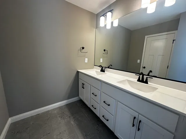 a bathroom with a double vanity sink and a mirror