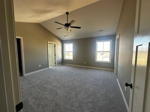 a view of a big room with windows and chandelier fan