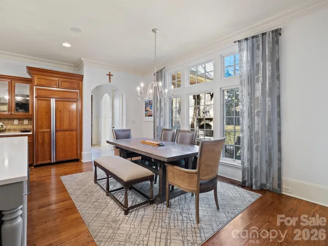 a dining room with stainless steel appliances kitchen island granite countertop a dining table and chairs