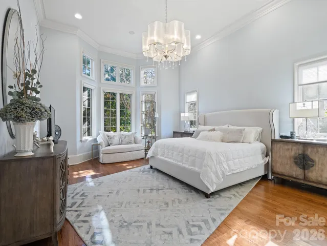 a spacious bedroom with a bed and a chandelier