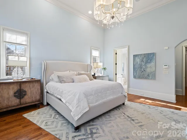 a spacious bedroom with a large bed and a chandelier