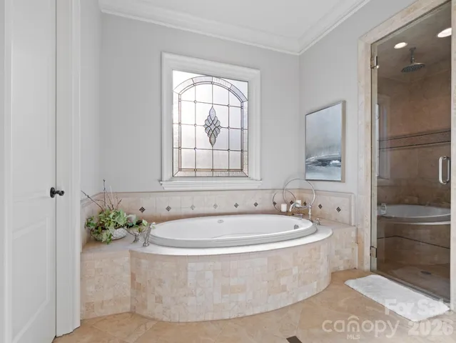a white bath tub sitting in a bathroom near shower
