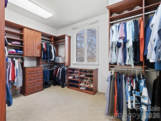 a view of walk in closet with clothes and shoes