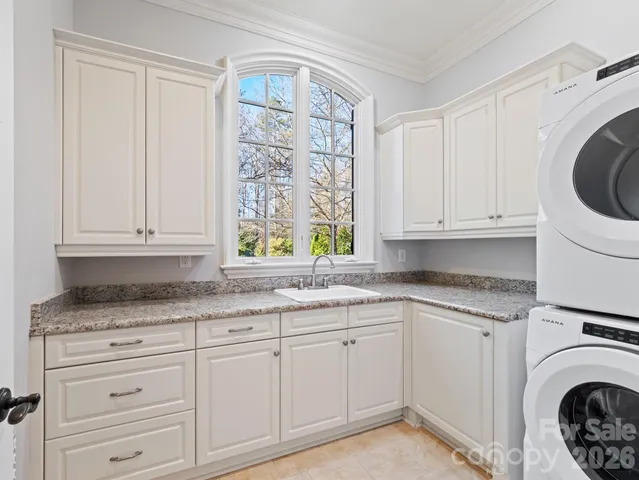 a kitchen with granite countertop white cabinets and a sink
