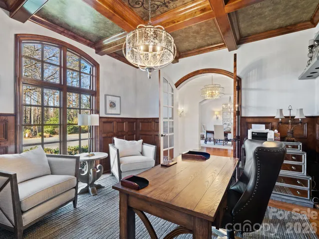 a living room with furniture a chandelier and a large window