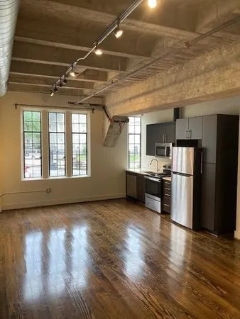 a view of kitchen with refrigerator and wooden floor