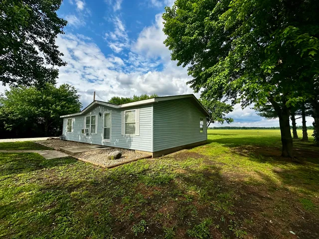 a view of backyard of house with green space