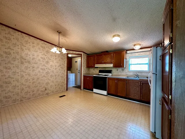 a kitchen with stainless steel appliances kitchen island granite countertop a refrigerator and a stove top oven
