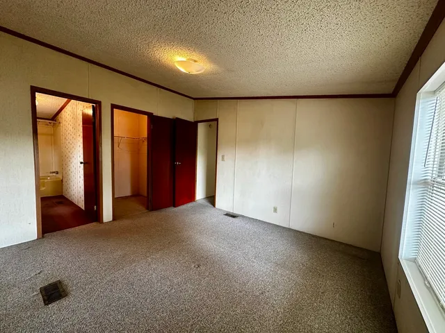an empty room with windows and closet