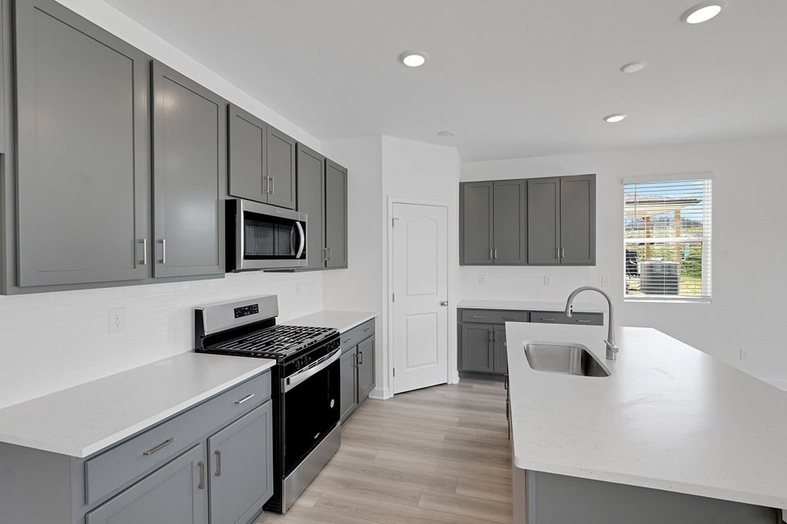 199 East Millbrook Drive Spring Hill, TN 37174 - Photo 11 of 32 a kitchen with kitchen island granite countertop a sink and stove top oven