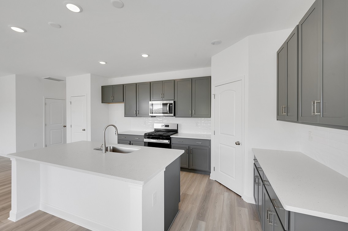 199 East Millbrook Drive Spring Hill, TN 37174 - Photo 10 of 32 a kitchen with a sink a stove a refrigerator cabinets and a wooden floor