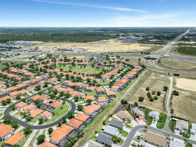 an aerial view of a swimming pool with a yard and seating