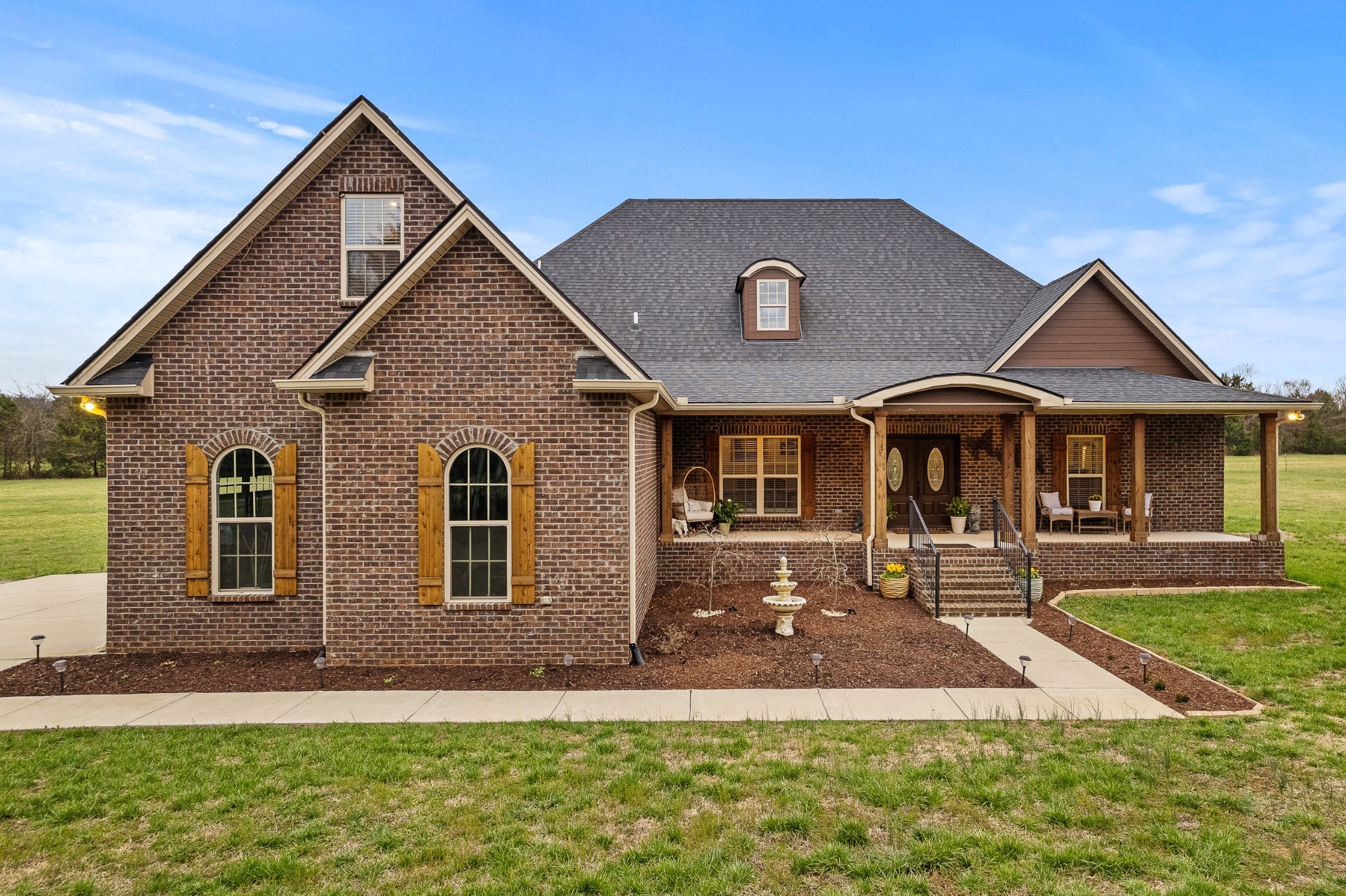 a front view of a house with yard and green space