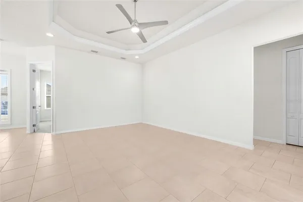 en empty room with an entryway and chandelier fan