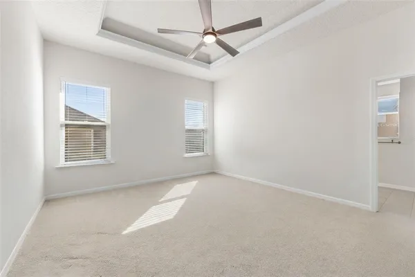 an empty room with windows and fan