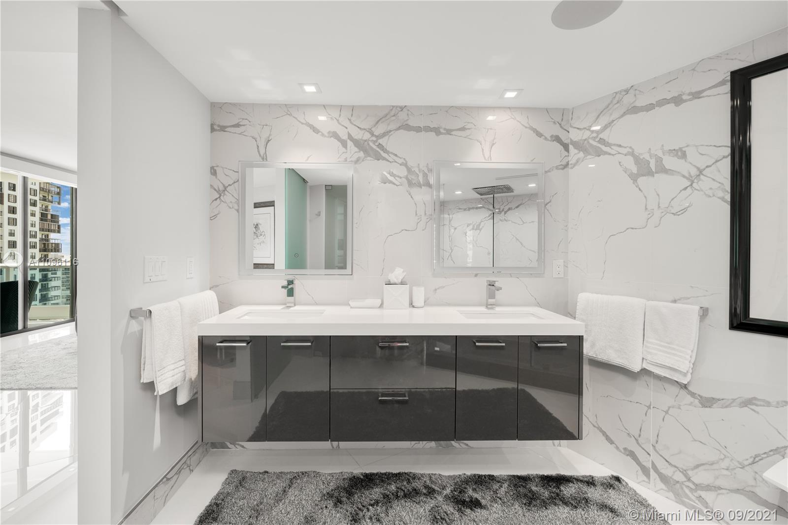 2127 Brickell Avenue, Unit 1602 Miami, FL 33129 - Photo 14 of 40 a spacious bathroom with a sink and a mirror