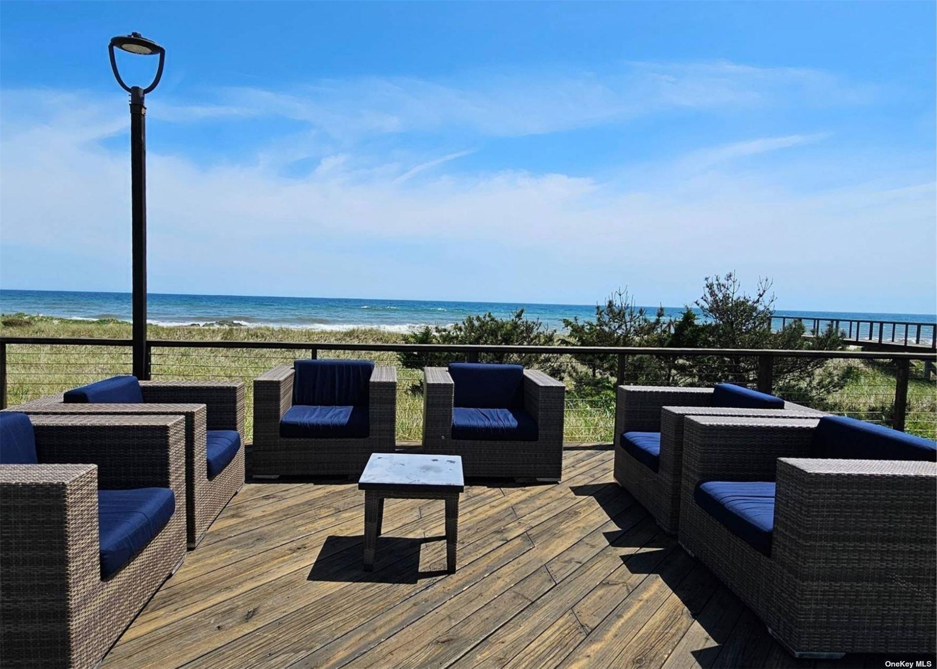 585 Dune Road, Unit L9 Westhampton, NY 11978 - Photo 11 of 20 a roof deck with a table and chairs