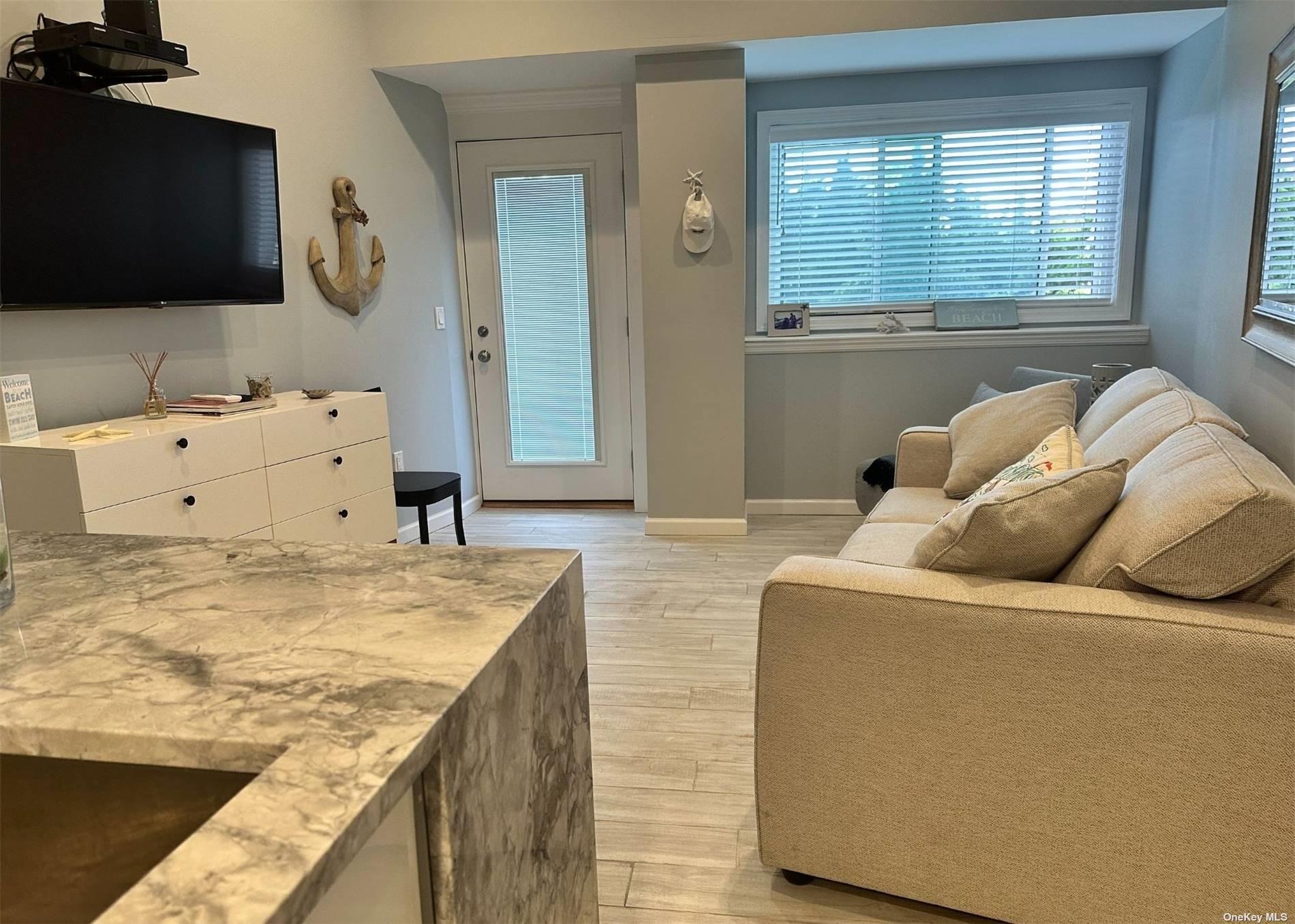 585 Dune Road, Unit L9 Westhampton, NY 11978 - Photo 4 of 20 a living room with furniture and a flat screen tv