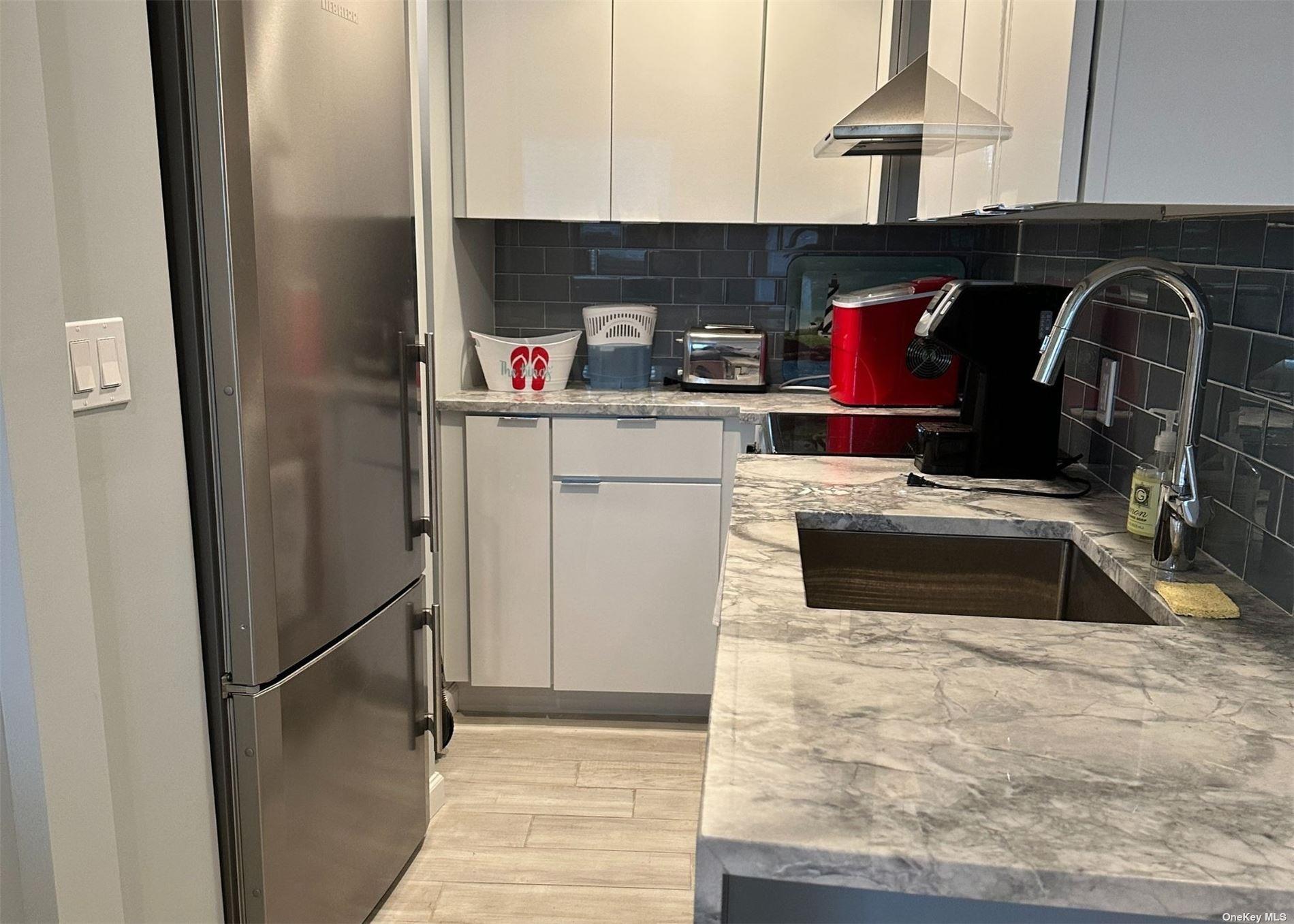 585 Dune Road, Unit L9 Westhampton, NY 11978 - Photo 6 of 20 a kitchen with a refrigerator and a stove