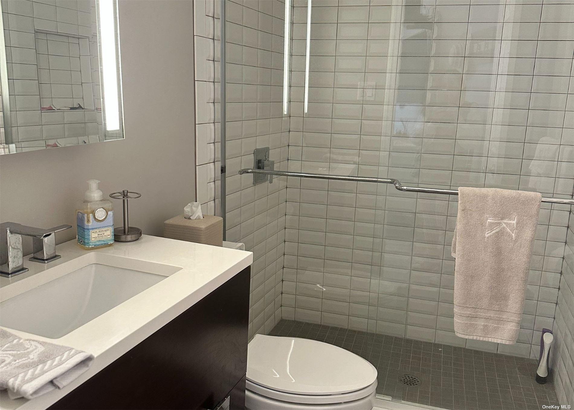 585 Dune Road, Unit L9 Westhampton, NY 11978 - Photo 8 of 20 a bathroom with a sink a toilet and shower