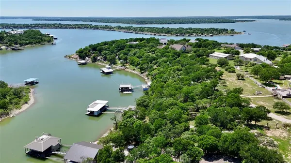 an aerial view of a house with a yard and lake view
