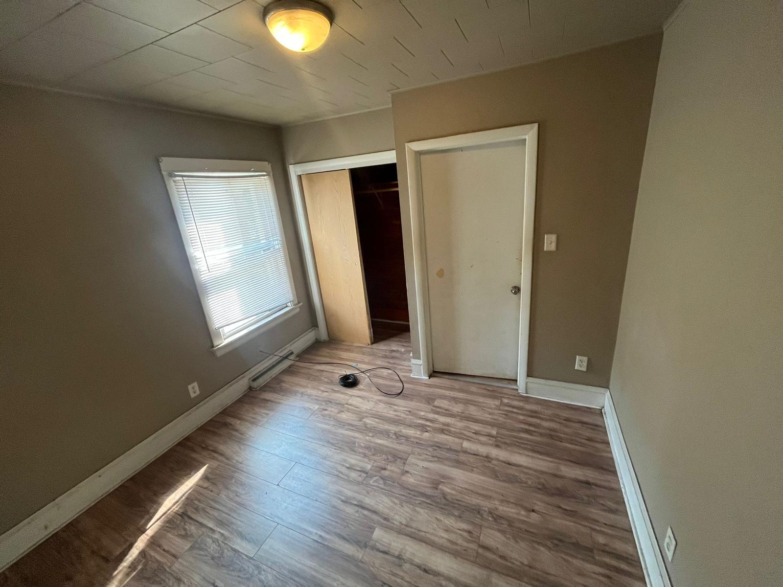 769 Buchanan Street Gary, IN 46402 - Photo 13 of 28 an empty room with wooden floor and windows