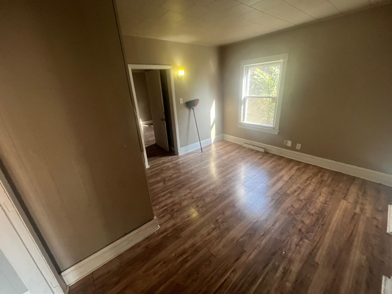 769 Buchanan Street Gary, IN 46402 - Photo 23 of 28 a view of an empty room with wooden floor and a window