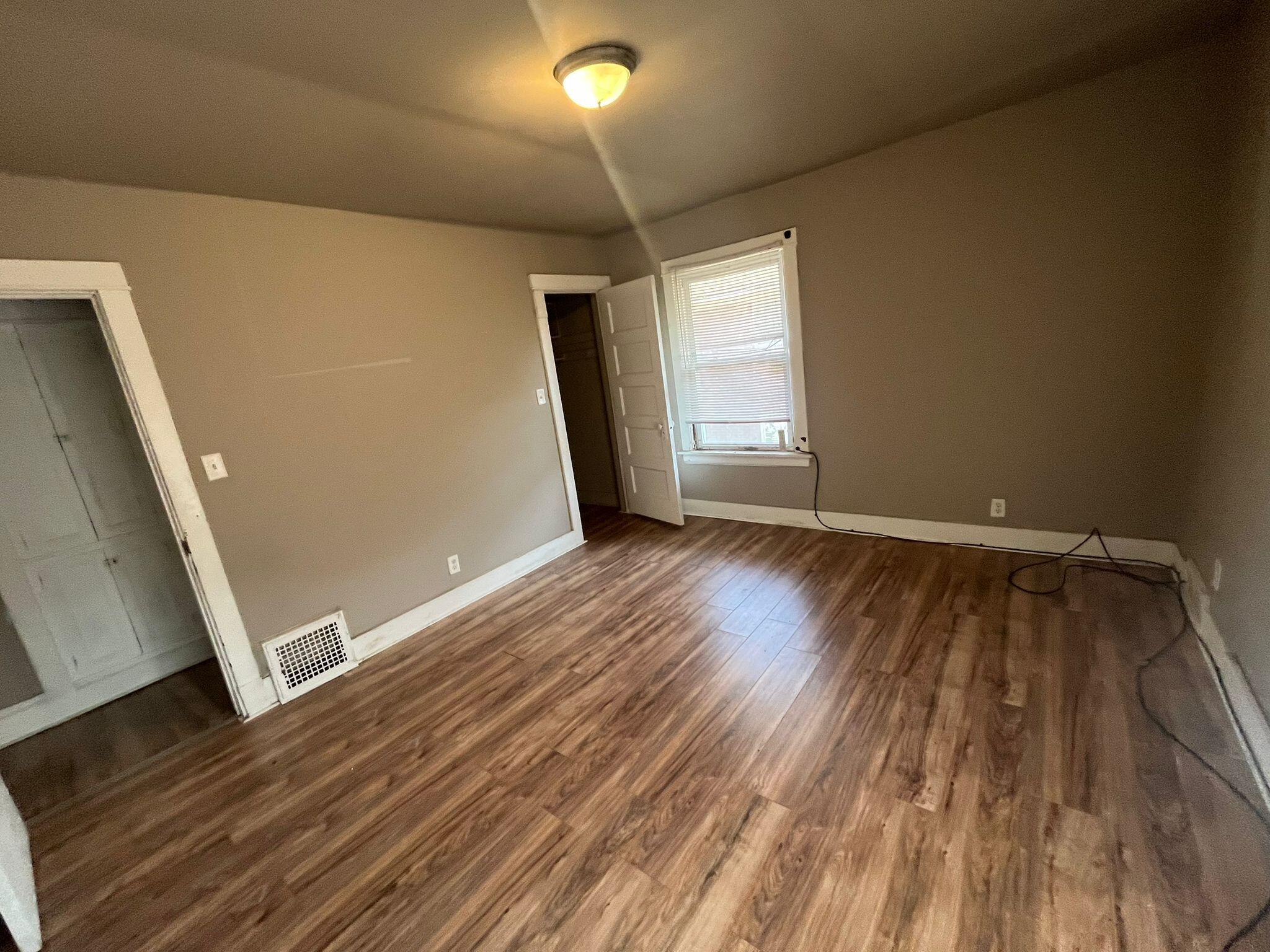 769 Buchanan Street Gary, IN 46402 - Photo 4 of 28 a view of an empty room with wooden floor and a window