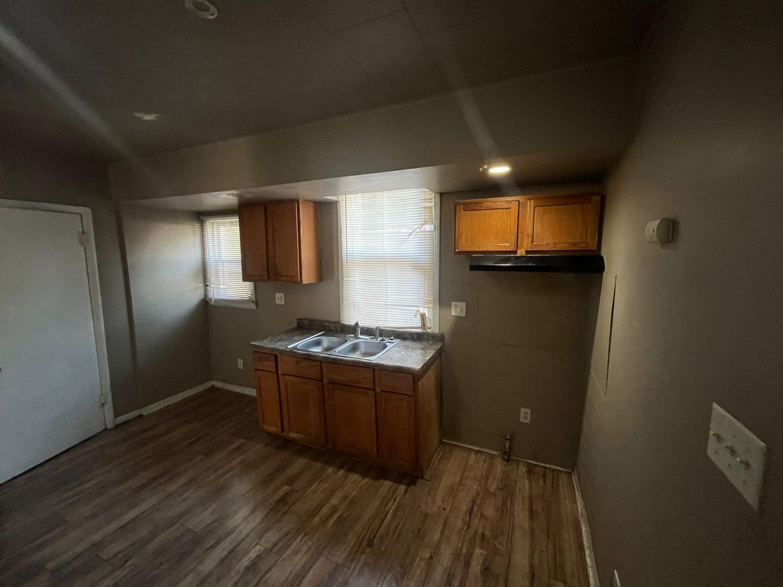 769 Buchanan Street Gary, IN 46402 - Photo 8 of 28 a kitchen with wooden floor and stainless steel appliances