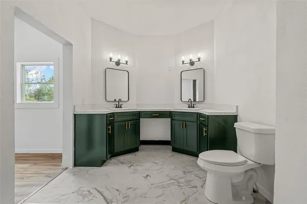 a bathroom with a toilet sink and mirror