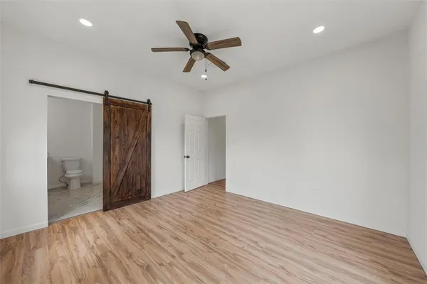 a view of empty room with wooden floor and ceiling fan