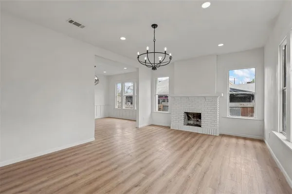 a view of empty room with wooden floor and fireplace