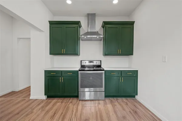 a kitchen with a refrigerator and a stove top oven