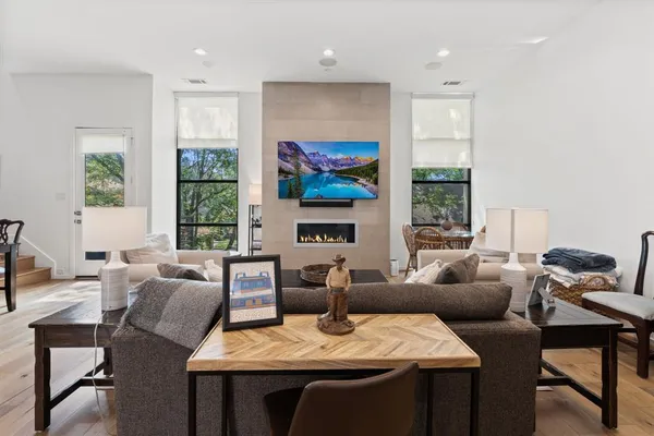 a living room with fireplace furniture and a large window