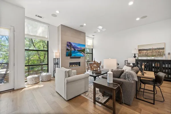 a living room with furniture kitchen view and a flat screen tv