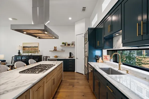 a kitchen with a stove sink and cabinets