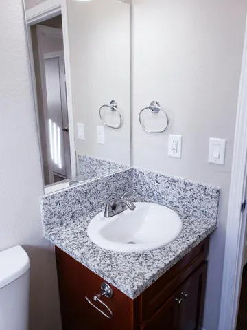 a bathroom with a granite countertop sink and a mirror