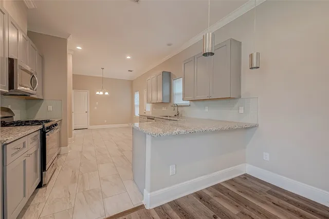 a view of granite countertop kitchen with granite countertop a sink and a stove top oven