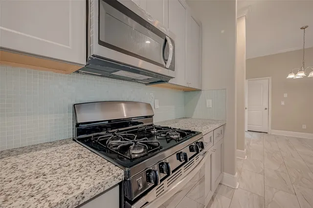 a stove top oven sitting inside of a kitchen